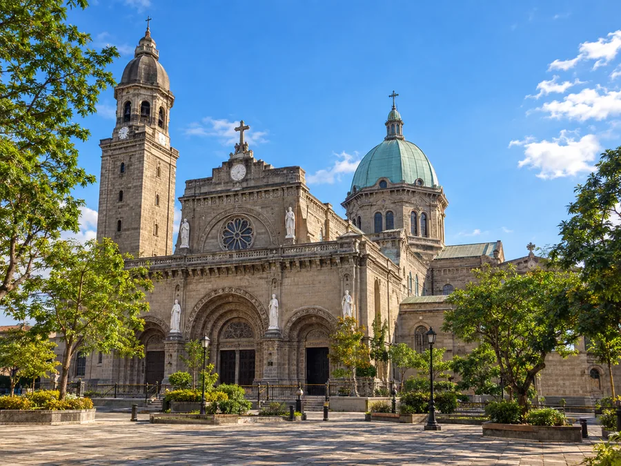 Ang batong harapan, simboryo at kampanaryo ng Manila Cathedral sa Intramuros sa isang maaraw na hapon